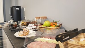 A breakfast buffet with pastries, fruits, and meats. - Almarossa (Bologna)