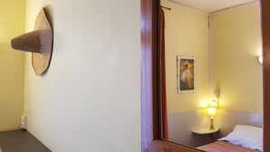 Habitación de hotel con cama, lámpara de noche, un cuadro en la pared y un tapiz tejido.