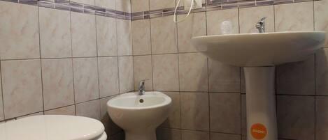 A bathroom with a toilet, bidet, and sink.