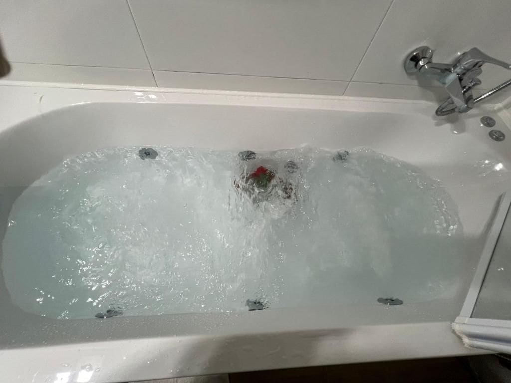 Amme, jossa on juoksevaa vettä, suihkupää ja hana.