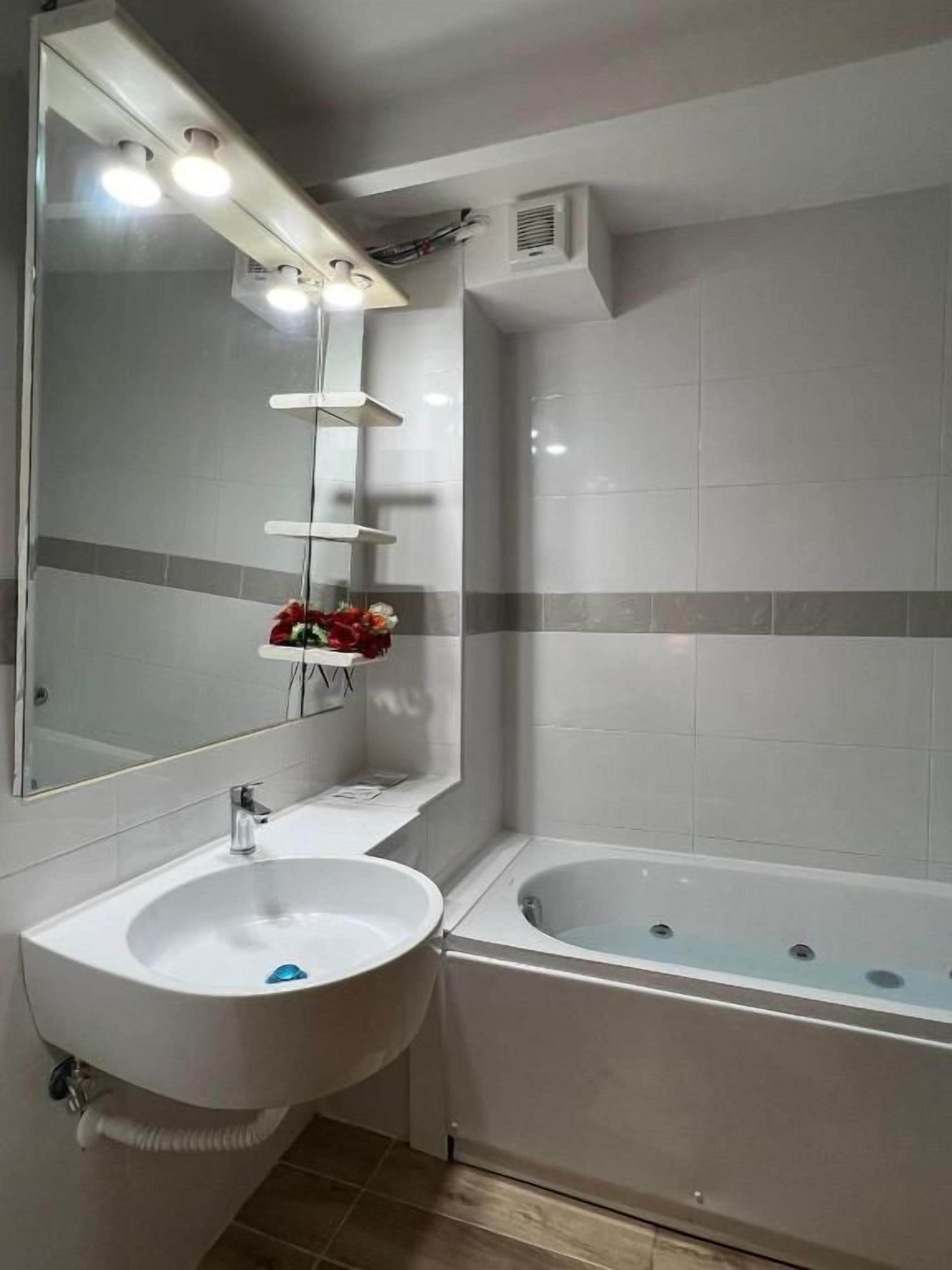 Un bagno con lavandino, specchio e vasca da bagno.