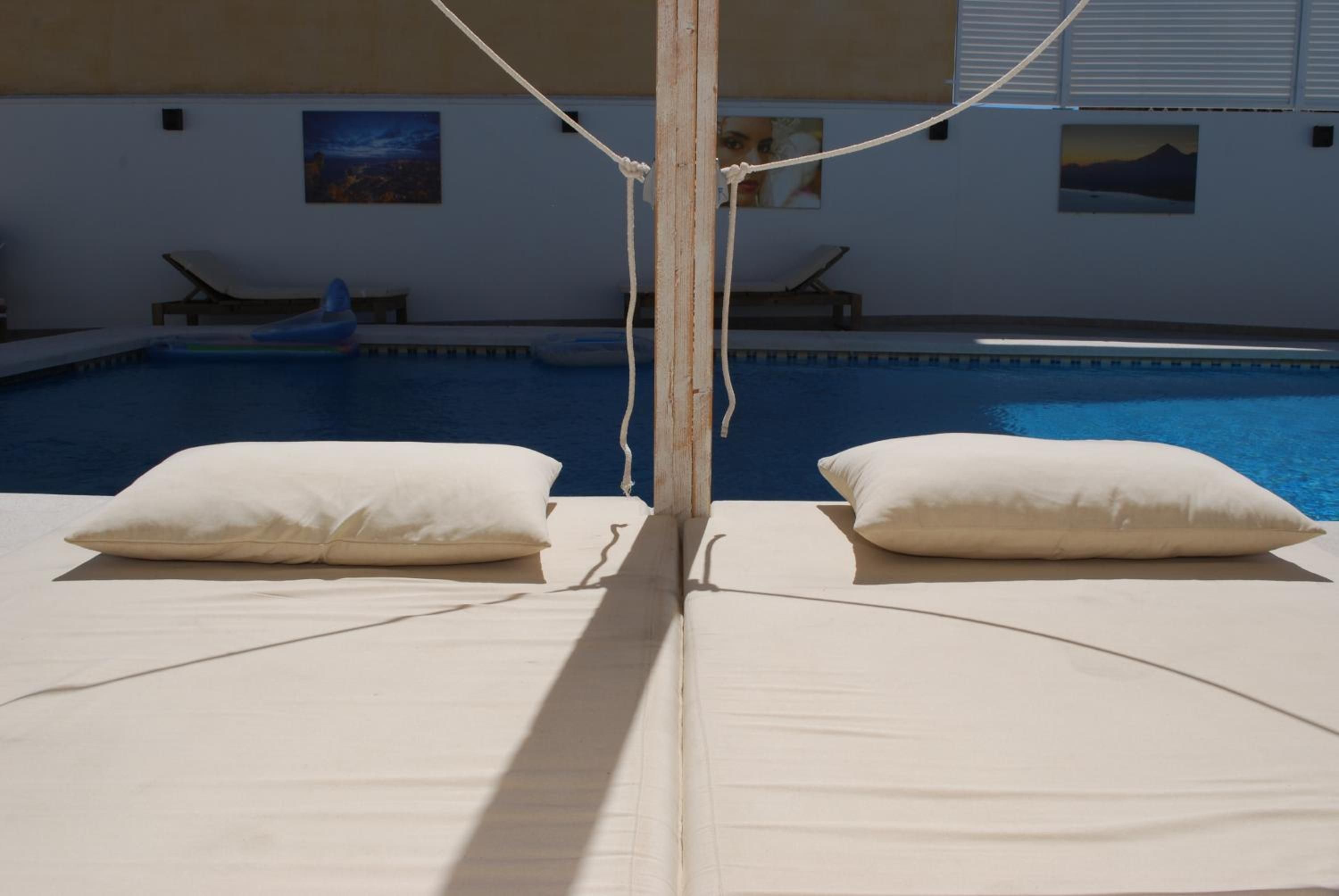 A poolside area with two lounge chairs and a pool.