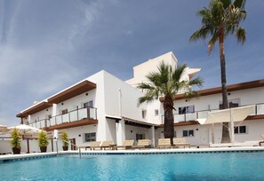 A modern hotel with a swimming pool, palm trees, and lounge chairs. - Hotel Moli Boutique (L'Alfas del Pi)