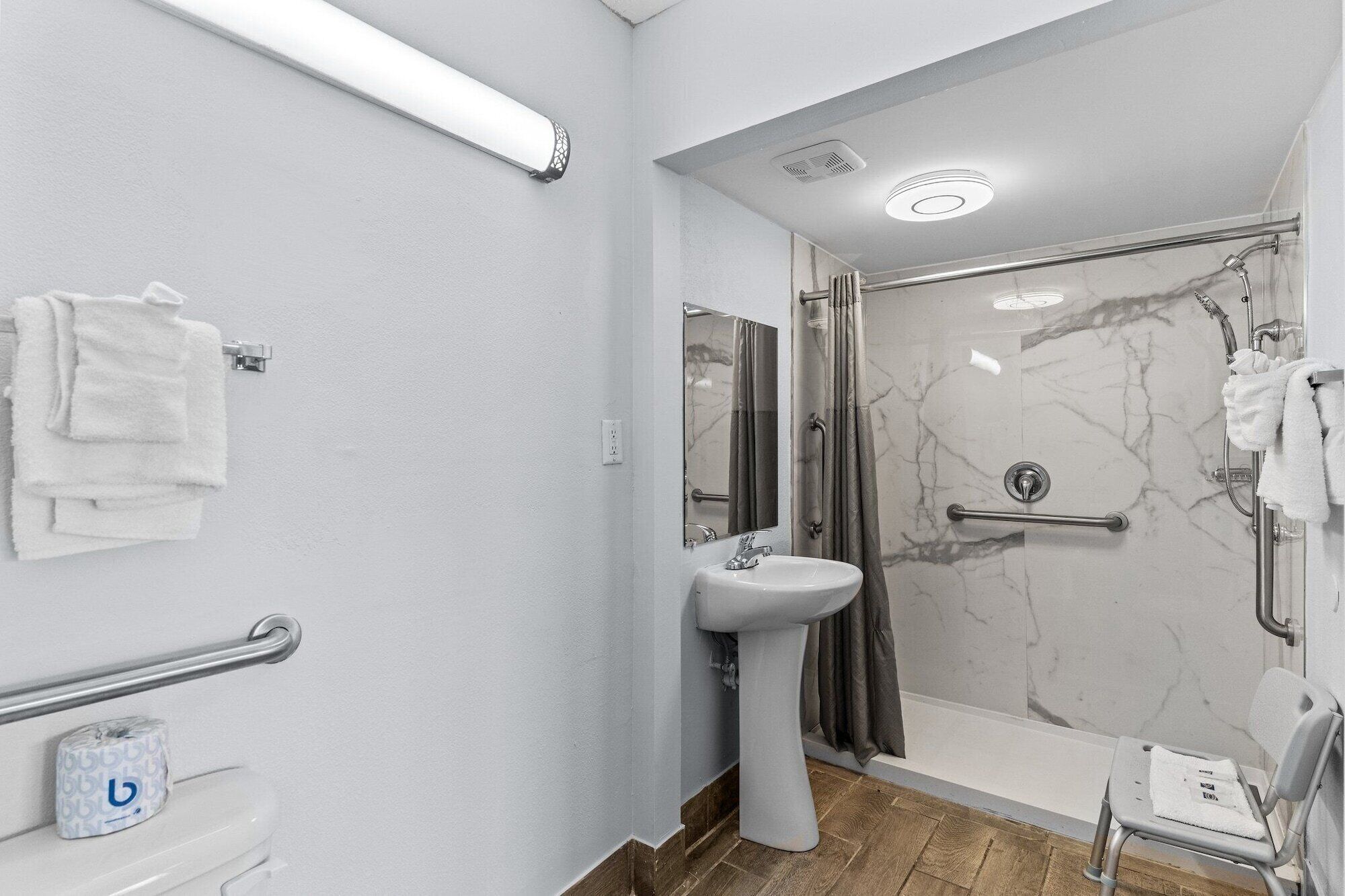 A modern bathroom with a shower, a sink, and a toilet.