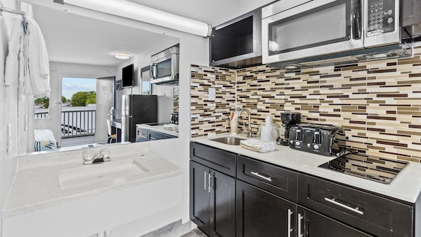 A modern kitchen with a microwave, toaster, and sink. - Studio 6 Wilmington, NC (Wilmington)