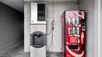 Un distributeur automatique et un point d’eau sont installés dans un couloir étroit aux murs de briques.