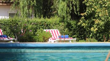 Una piscina con sillas de descanso y una bandera estadounidense.