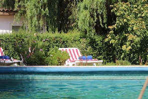 Una piscina con sillas de descanso y una bandera estadounidense.