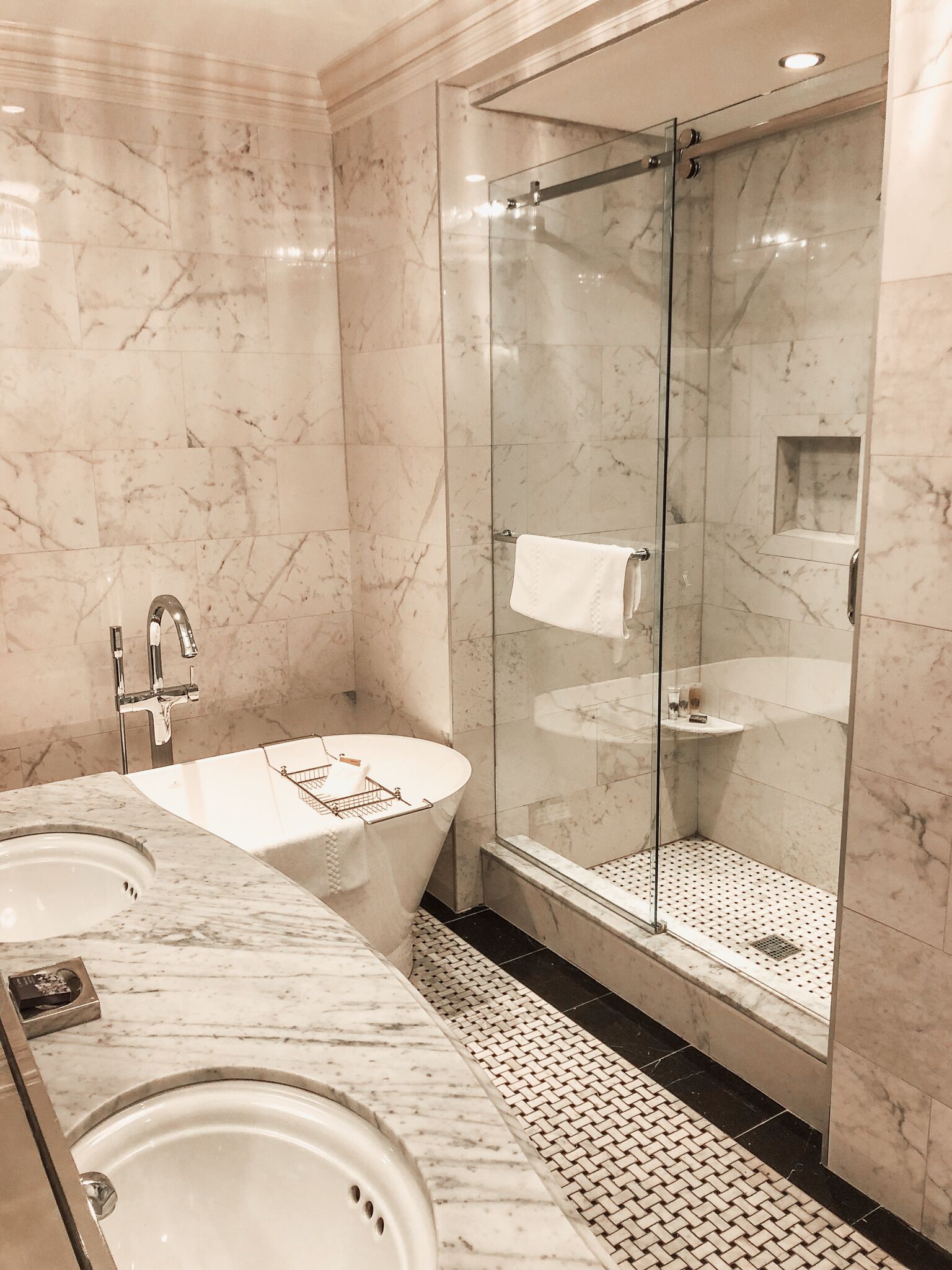A modern bathroom with a glass-enclosed shower, a freestanding bathtub, and a sink.