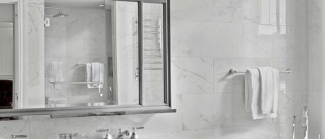 A modern bathroom with a large mirror, a vanity with a sink, and a freestanding bathtub.