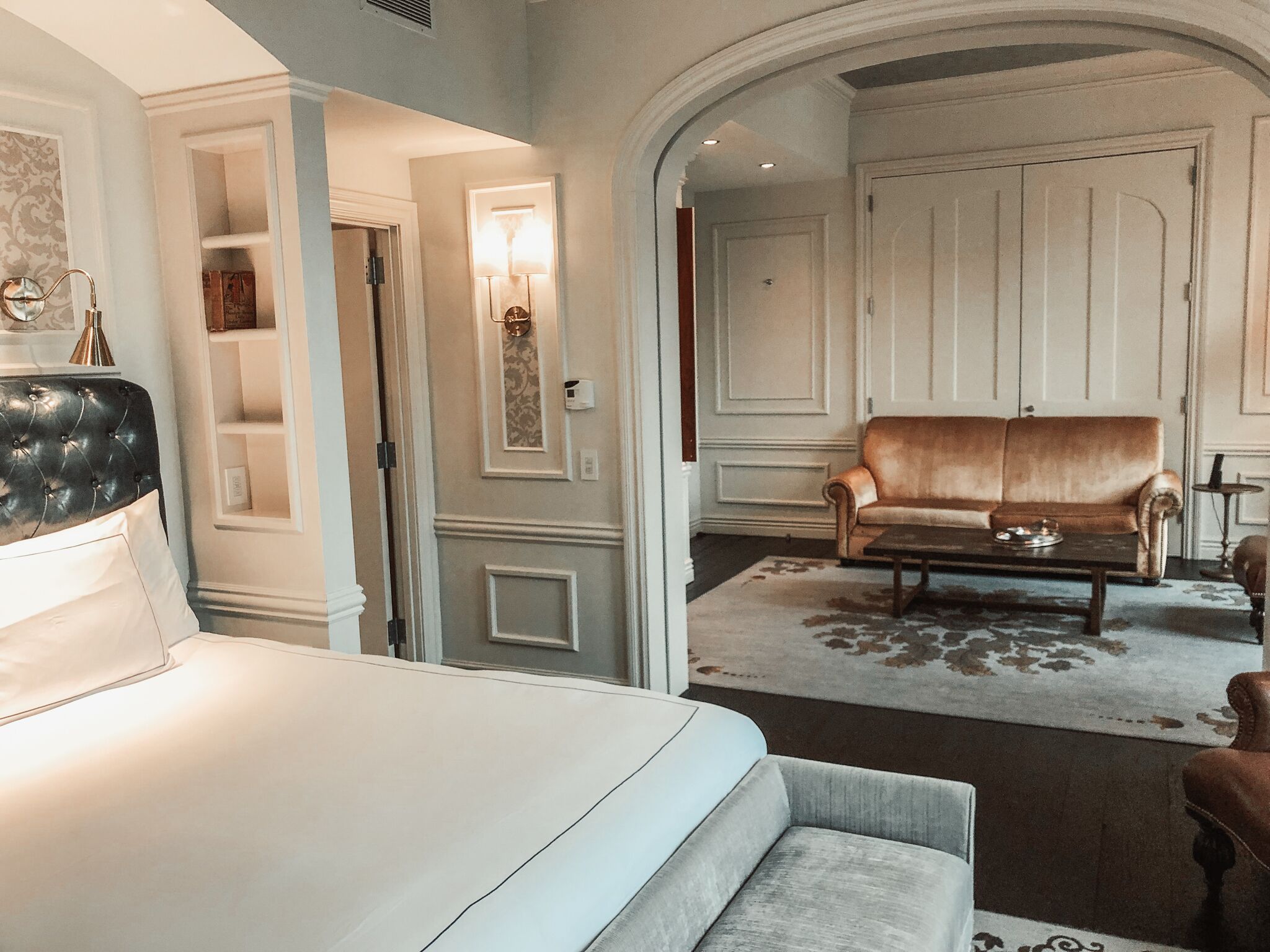 Una habitación luminosa y elegantemente amoblada con sofá, mesa de centro y cama.