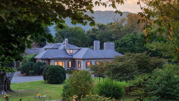 A stately house with a well-manicured lawn, a patio with outdoor furniture, and a view of the surrounding greenery. - Glen Gordon Manor (Huntly)