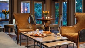 A dining area with a table set for two, featuring a bowl of bread, a glass of wine, and a vase of flowers. - Glen Gordon Manor (Huntly)