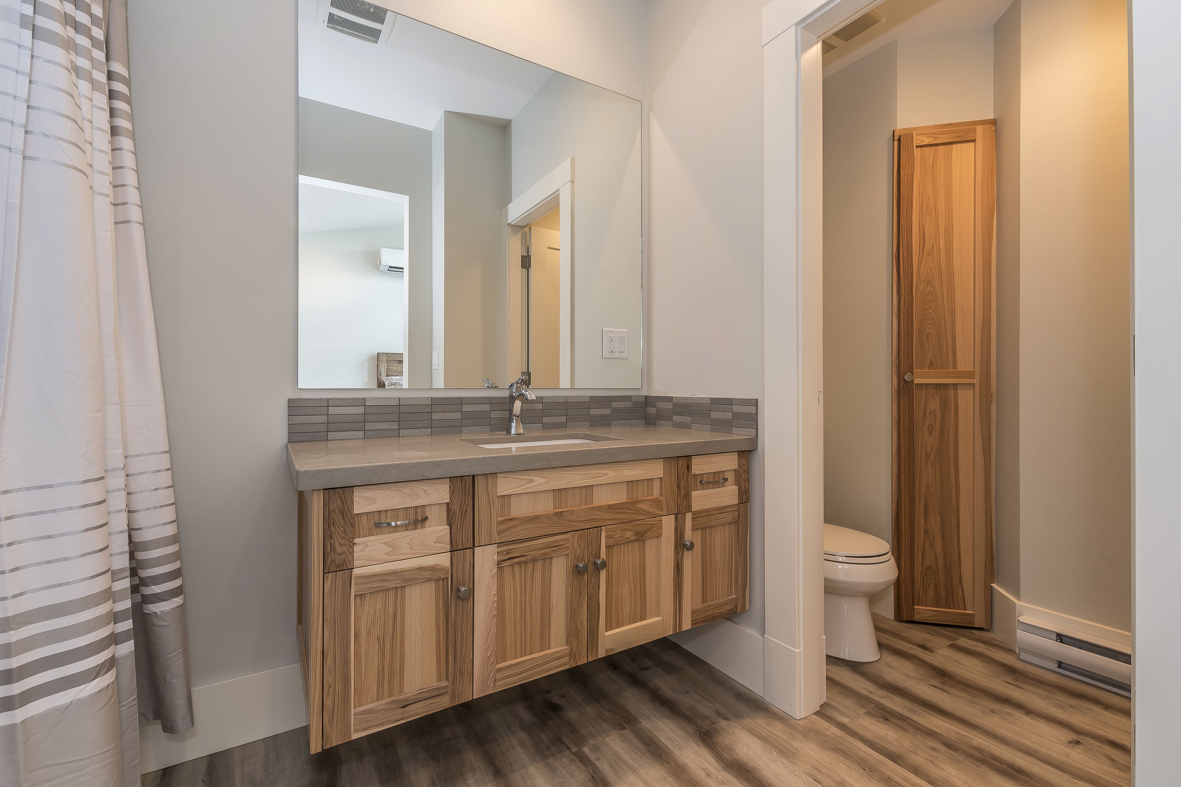 A bathroom with wooden cabinets, a sink, and a toilet.