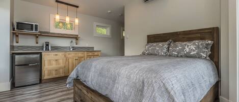 A bedroom with a wooden bed, a gray bedspread, and a wooden nightstand.