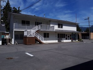 A two-story building with a balcony, a staircase, and a small porch area. - Park Motel (Hope)