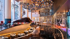 Een moderne lobby met een glanzende vloer, een grote sculptuur van een boot en een opvallend plafondontwerp.