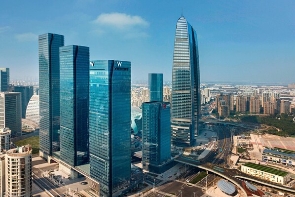 A cityscape with modern skyscrapers, including a distinctive curved building and several rectangular high-rises. - W Suzhou (Suzhou)