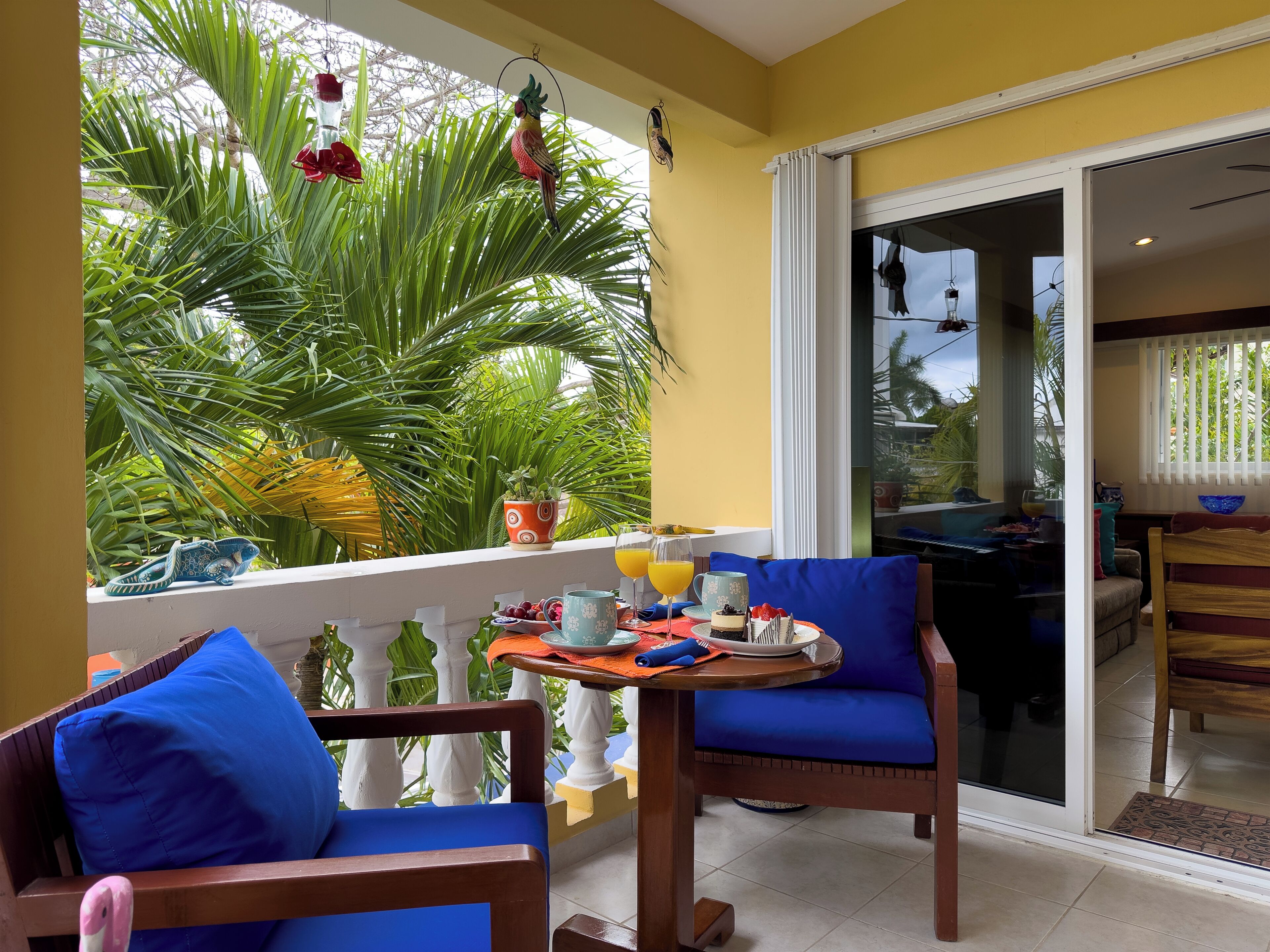 A balcony with a table set for breakfast, a chair, and a view of the outdoors.