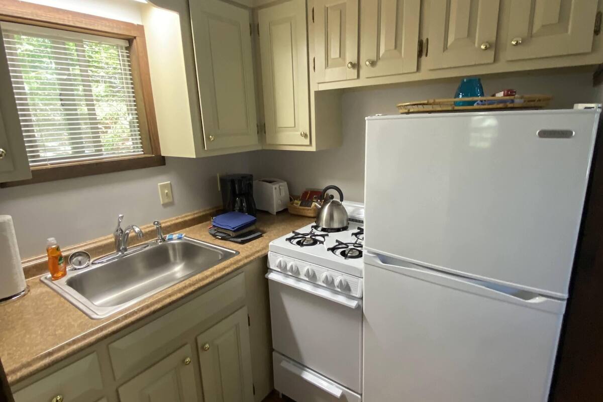 A compact kitchen with a sink, stove, and refrigerator.