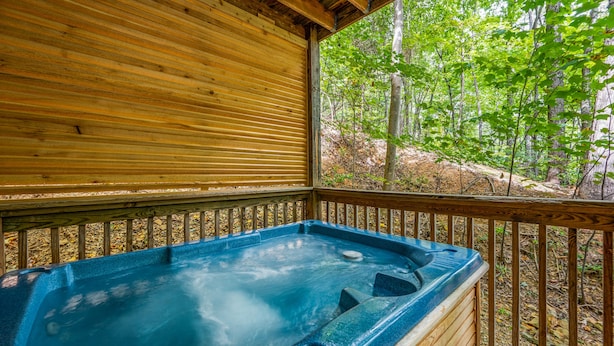 A wooden deck with a hot tub surrounded by a forest. - 1 Bedroom, Sleeps 4, Minutes To Downtown Gatlinburg, Pool Table (Gatlinburg)