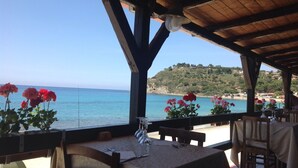 A seaside restaurant with outdoor seating, a view of the sea, and a hillside in the background. - Stunning studio holiday apartment for 2/3 on resort, close to beach with 2 pools (Pizzo)