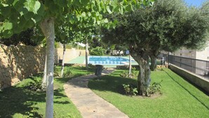 A stone pathway leading to a pool area with a stone wall and a metal fence. - Nice apartment 500 meters from the beach, Pool, Parking, Wi-Fi, Satellite TV (SANTA POLA)