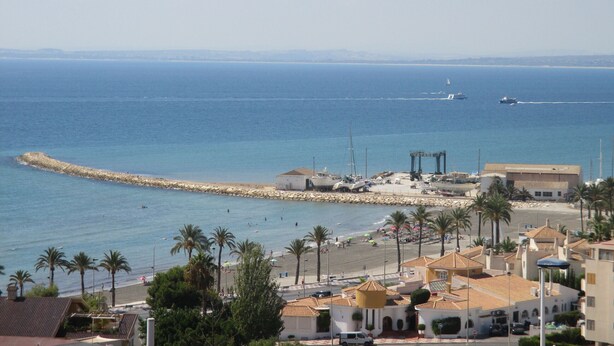 A coastal town with a beach, palm trees, and a rocky breakwater. - Nice apartment 500 meters from the beach, Pool, Parking, Wi-Fi, Satellite TV (SANTA POLA)
