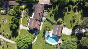 Vista aérea de una zona residencial con varias casas, una piscina y jardines cuidados.