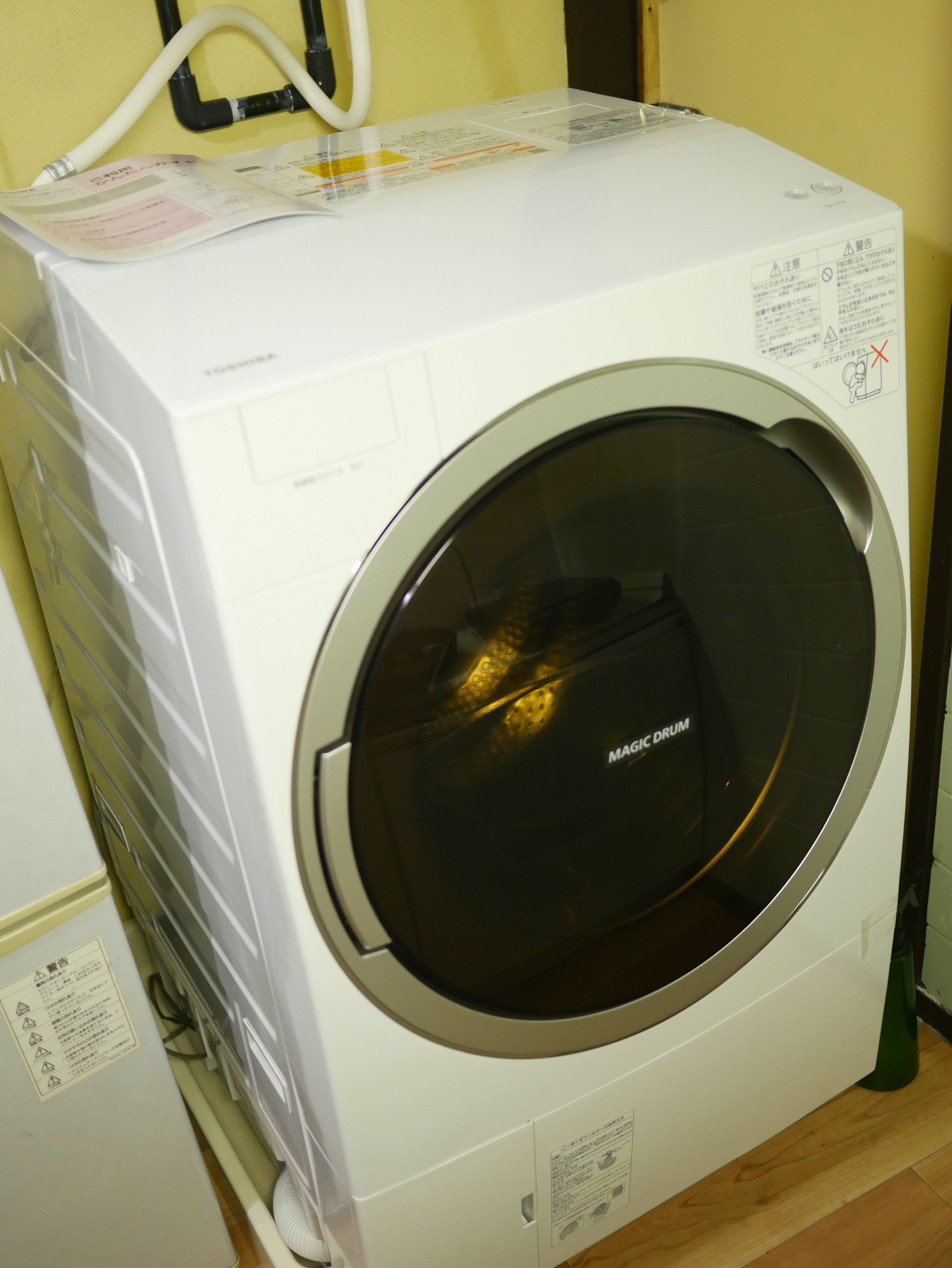 A front-loading washing machine with a front control panel and a large circular door.