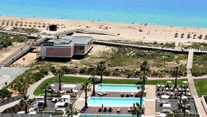 Un complexe hôtelier situé en bord de mer, doté d’une piscine, d’une plage et d’une promenade en bord de mer.