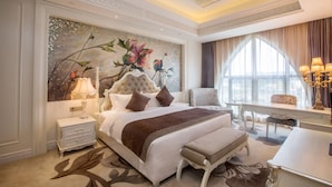 A spacious bedroom with a large bed, a desk, and a view of the city. - Changzhou Joyland Gloria Grand Hotels (Changzhou)