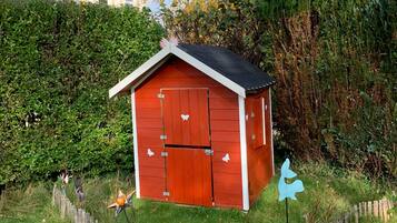 Situated in a serene garden, this charming shed offers a peaceful retreat.