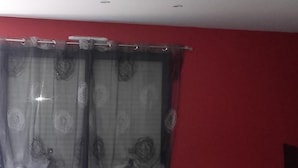 Un saló amb un sofà gris, una taula de centre de fusta i una paret vermella d'accentuació.
