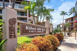 A sign for 'Kihei Alii Kai' at 2387 S. Kihei Rd. with a view of a multi-story building and palm trees. - 30% Disc Last Min, 48 Hr Cancel, Partial Ocean Vw,  A/C, 3 min to Beach (Kihei)