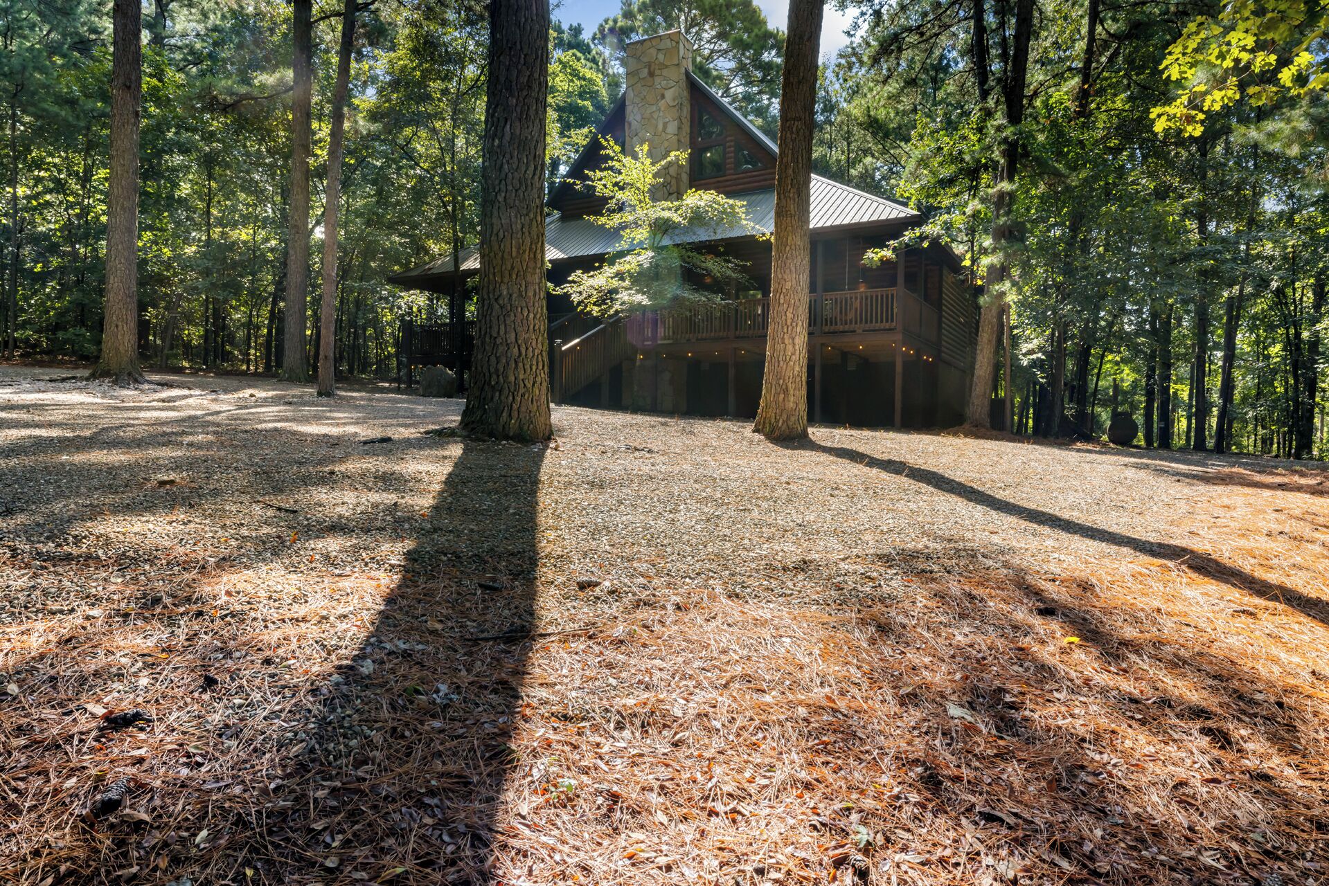Eine Lodge mit einem Steinkamin, umgeben von einem Wald.
