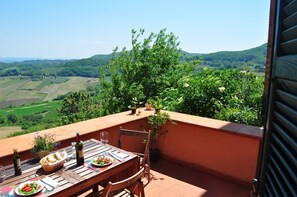 A terrace with a table set for two, overlooking a scenic landscape with fields and hills. - INDEPENDENT HOUSE LARGE TERRACES & SPECTACULAR VIEWS in CENTER W. PARKING (Montepulciano)