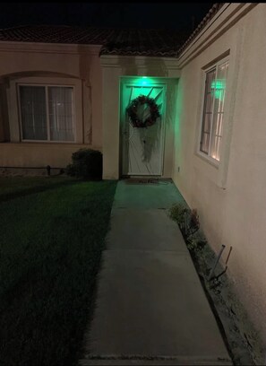 A house with a front door, a wreath, and a green light.