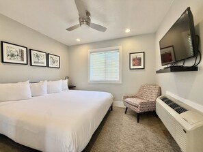 A hotel room with a large bed, a ceiling fan, a mounted TV, and framed artwork on the walls. - Tiny Home near Zion with Loft & Resort Pools (Orderville)