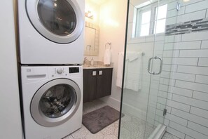 A laundry area with a washing machine and dryer, a small bathroom with a shower, and a tiled floor. - Tiny Home near Zion with Loft & Resort Pools (Orderville)