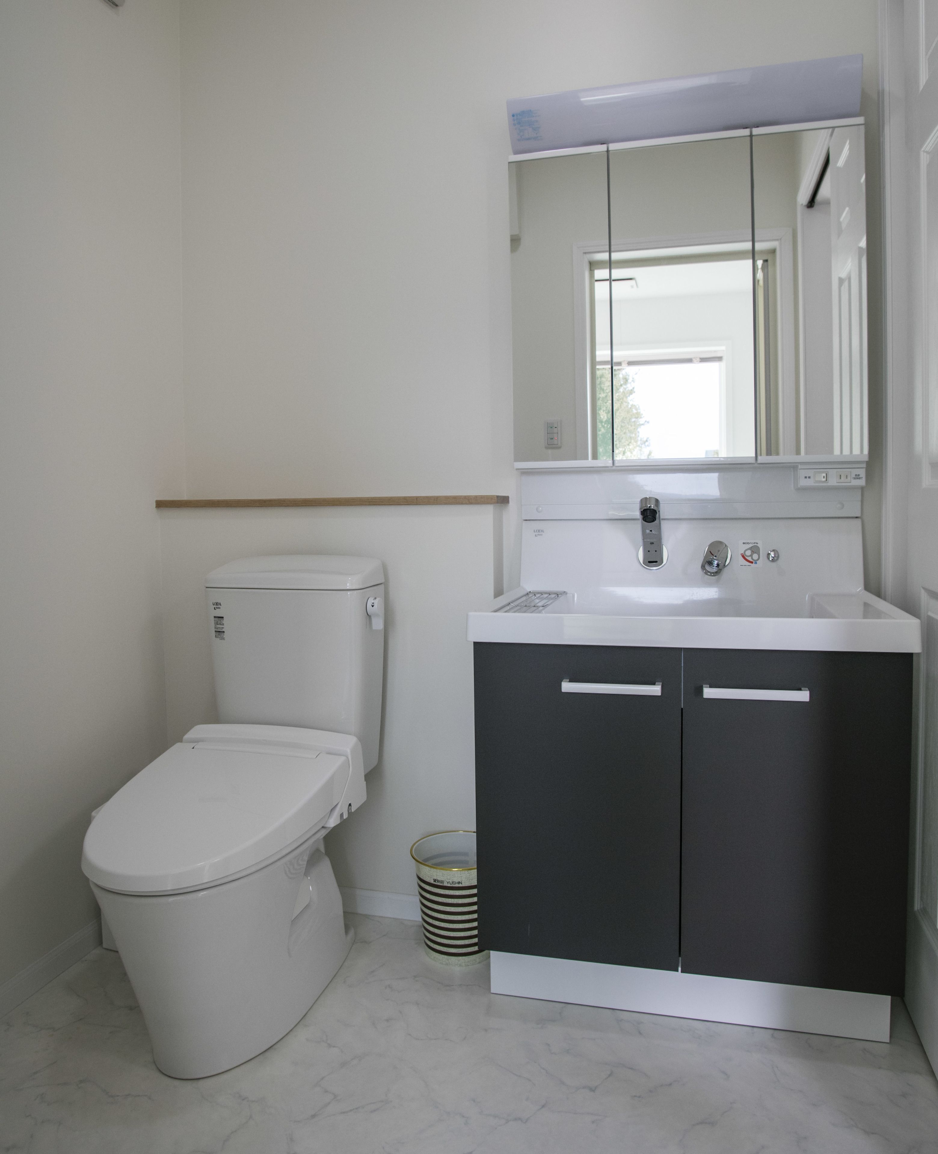 Un bagno con il water, un lavandino e uno specchio.