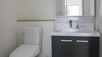Un bagno con il water, un lavandino e uno specchio.