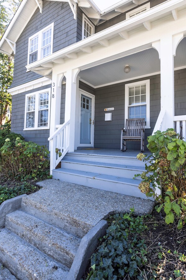 A two-story house with a porch, a front door, and a bench. - Magnificent, original Va Beach home located a 3 minute walk from the ocean! (Virginia Beach)