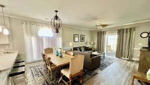 A spacious living area with a dining table, chairs, a sofa, and a ceiling fan. - Myrtlewood Condo 1 Mile To Beach - Feel At Home. (Myrtle Beach)