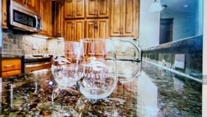 Una cocina con armarios de madera, un microondas y dos vasos sobre la encimera.