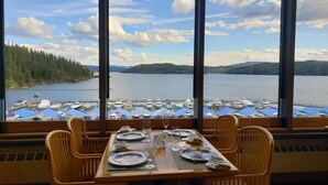 Mesa de comedor para cuatro con vista a un lago y botes.