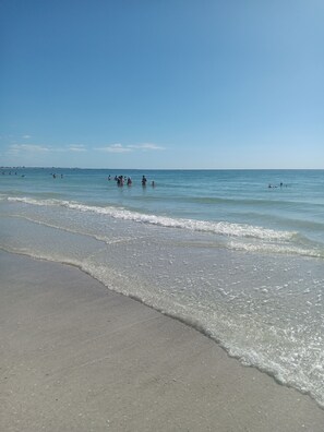 Una platja amb cel blau clar i aigües tranquil·les.