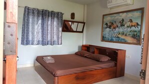 Un dormitorio con cama de madera, una cortina, un cuadro y un termostato.
