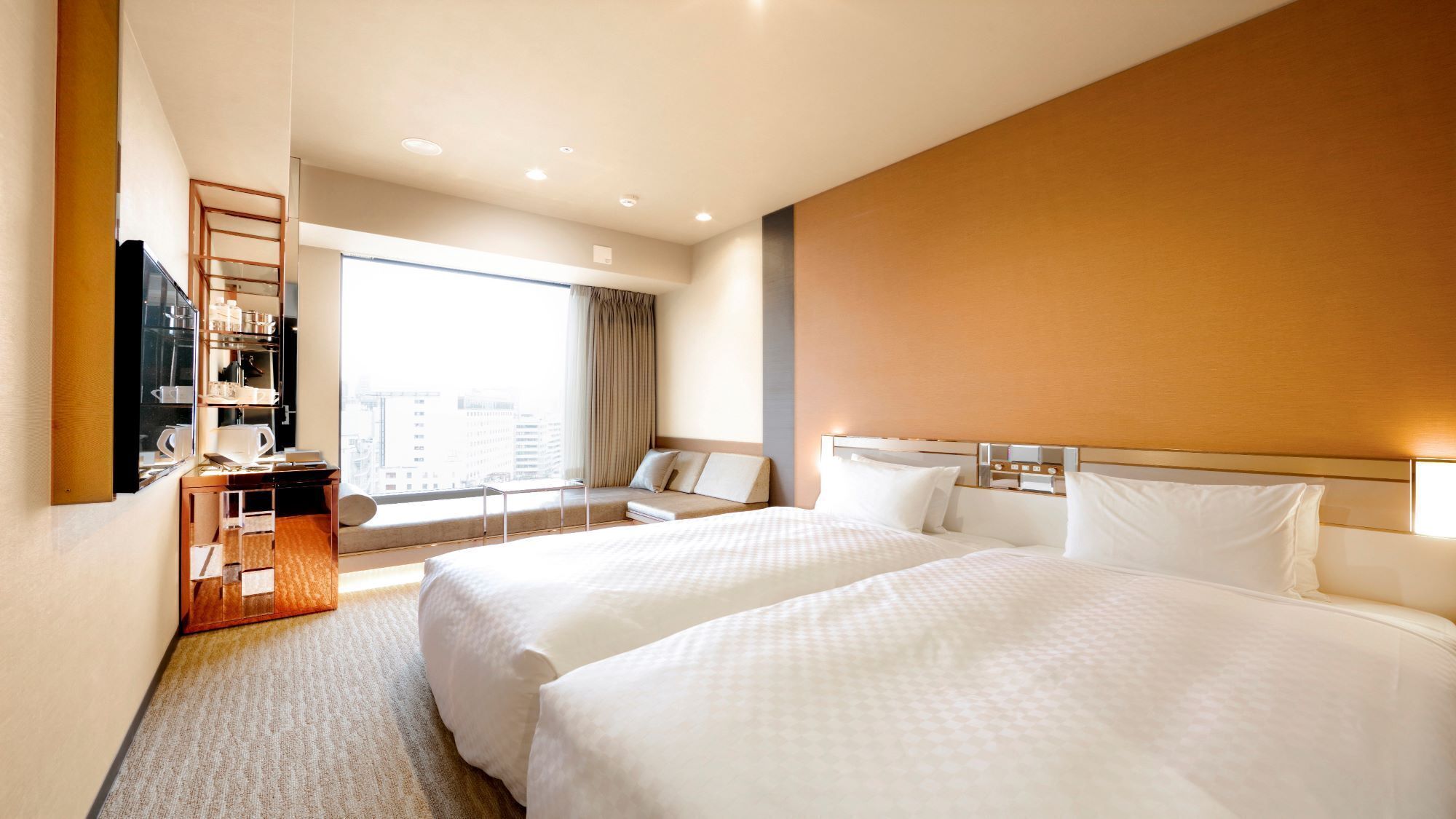 A hotel room with two beds, a seating area with a view, and a minibar.