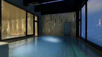 A modern hotel room with a large window overlooking a cityscape, a spacious interior, and a visible bathroom area.